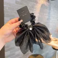 Detail of black bow hair scrunchie with shimmering silver star glitter and metallic pendant - Black