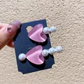 Detalle de pinzas para el pelo de corazón rosa con perlas en una tarjeta - Juego de Joyas Rosa