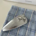 Close-up of a silver BB hair clip featuring a bow and sparkling heart-shaped crystals - Enamel Snap Clip (B756) / Silver Leather Small Butterfly