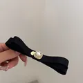 Eleganter schwarzer Haarschleifenclip mit zentralem Edelstein und Perlenakzenten - Schleife G-Tag Stil / Schwarz