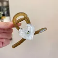 Dettaglio della pinza per capelli ambra con motivo a cuore bianco e strass verde - Cuore Bianco Avorio