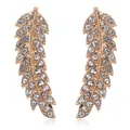 Close-up of rose gold leaf earrings with sparkling rhinestone crystals on white background - Gold