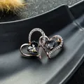 Vista detallada del broche de doble corazón con cristales grises y baño de oro rosa - Gris