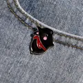 Gros plan d'une broche chat en émail noir avec écharpe rouge sur tissu denim - Style Chat Lapin Dessin Animé Noir / Noir