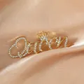 Elegant gold Queen brooch with rhinestones and crown detail on champagne silk fabric - Gold