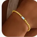 Detail of gold beaded bracelet featuring a rectangular light blue zircon gemstone - 14k / Gold March (Light Blue)