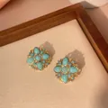 Macro detail of vintage gold plated brass earrings with teardrop turquoise stones - Floral Cluster (e005)