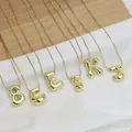 Detail of 3D gold bubble letter pendants with glossy finish and delicate chain - 14k / Letter K