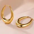 Boucles d'oreilles créoles ovales dorées brillantes sur fond en soie élégante - 14k / Or
