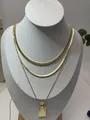 Detailed close-up of layered gold necklace with twisted circle pendant and cuban links - Three-Layer Pendant Style 3 (x252) / Set of 3 / Gold