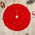 Red Christmas tree skirt with white embroidery and colorful pom-poms on wooden floor - Red Embroidery Style