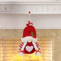 Knitted Christmas gnome ornament with red hat and heart detail on festive fireplace - Faceless Girl Gnome Style