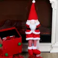 Christmas gnome plush toy with long legs and red hat in festive fireplace setting - Red Shy Long-legged Doll