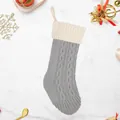 Calza di Natale in maglia a trecce grigia e bianca con gancio su fondo marmo - Calza in maglia patchwork grigia