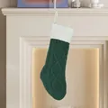 Donkergroene gebreide kerstsok met kabelpatroon en witte boord bij de haard - Witte Boord Groen Lijf Gebreide Sok