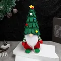 Christmas gnome doll with green tree hat and white beard on a festive stage - Green Christmas Tree Hat Sitting Gnome