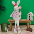 Gnome lapin de Pâques en robe fleurie rose avec de longues jambes assises sur un banc - Lapin À Longues Jambes Rose