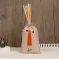 Rustic linen harvest gift bag featuring a snowman face and straw details on dark wood - Bundle Style