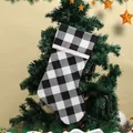 Festive black and white buffalo check Christmas stocking with plush cuff hanging on a tree - Black And White Plaid Christmas Stocking