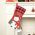 Large red Christmas stocking with snowman print and red-black plaid trim hanging on fireplace - Snowman Christmas Sock