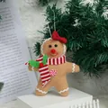 Gingerbread man plush ornament with red bow and striped scarf on Xmas tree branch - Gingerbread Man with Bow