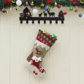 Linen Christmas stocking with 3D Santa Claus figure hanging from a decorative wall hook - Santa Claus