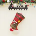 Large red burlap Christmas stocking with snowman patch hanging with holiday ornaments - Snowman
