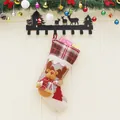 Chaussette de Noël avec poupée renne 3D et motif à carreaux sur un mur de fête décoré - Style Élan