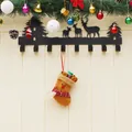 Black metal reindeer silhouette wall hook rack with Christmas stocking in home setting - Elk Style