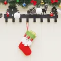 Roter Weihnachtsmann-Socken am Metallhaken mit Tannennadeln und Glocken als Dekoration - Weihnachtsmann