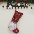 Weihnachtsstrumpf mit 3D-Weihnachtsmann und rotem Karomuster an einer festlichen Wand - Weihnachtsmann