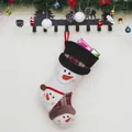 Weihnachtsstrumpf mit Schneemanndesign und Zylinder an Holzwand mit Weihnachtsdekoration - Schneemann
