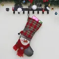 Weihnachtsstrumpf Geschenktüte mit Schneemann-Motiv und Karomuster auf Holzoberfläche - Schneemann