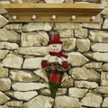 Weihnachts-Schneemann Plüsch-Anhänger mit rotem Schal und Karohut an der Steinwand - Schneemann