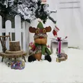 Weihnachts-Rentier-Plüschfigur mit grünem Hut und Schal auf weißem Teppich Deko - Elch-Stil