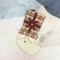 Plaid Christmas stocking with plush Santa Claus face and festive snowflake detail - Santa Claus