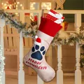 Dog paw Christmas stocking with Happy Howlidays print and gift box inside hanging on fence - Blue Paw Happy Howlidays