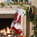 Christmas stocking with Santa Claus and gift box embroidery hanging by a fireplace - Santa Claus