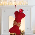 Red knit dog bone Christmas stocking with bow tie on a festive white fireplace - Red