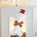 White bone-shaped knitted Christmas stocking for pets with a red polka dot bow - White