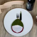 Gnome shaped Christmas felt cutlery holder in red and white on a wooden table - Green Gnome Style