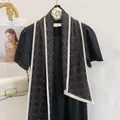 Dettaglio di elegante foulard in seta nera con motivi geometrici e bordo a contrasto - Nero Motivo a Croce Bordo Bianco