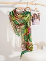 Pañuelo de seda con estampado artístico verde y rosa en una rama de madera natural - Estilo Remolino Verde