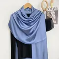 Dettaglio di sciarpa in raso celeste su gruccia in legno con texture setosa - Blu Denim
