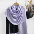 Dettaglio di uno scialle leggero in seta lavanda drappeggiato su un indumento nero - Viola Chiaro