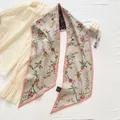 Macro shot of long floral silk scarf texture with detailed 100% silk wash label - Pink Floral Pattern