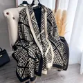Dettaglio ravvicinato di uno scialle in maglia geometrica con frange in nero e beige - Nero