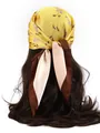 Rear view of a model wearing a floral yellow satin scarf tied in a bow on wavy hair - National Style Flowers - Yellow