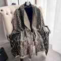Elegante scialle pashmina con motivi geometrici e frange su una sedia bianca - Nero