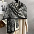 Dettaglio di un'elegante sciarpa con motivo a vortice bianco e nero e frange - Nero